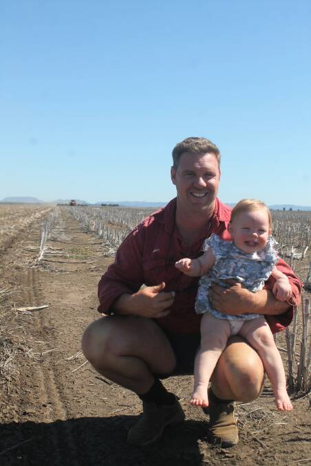Matt Travers with his daughter Harriet, 1, at their property Boongulla, Gindie, as the chickpea plant begins in the background. Picture: Ben Harden
