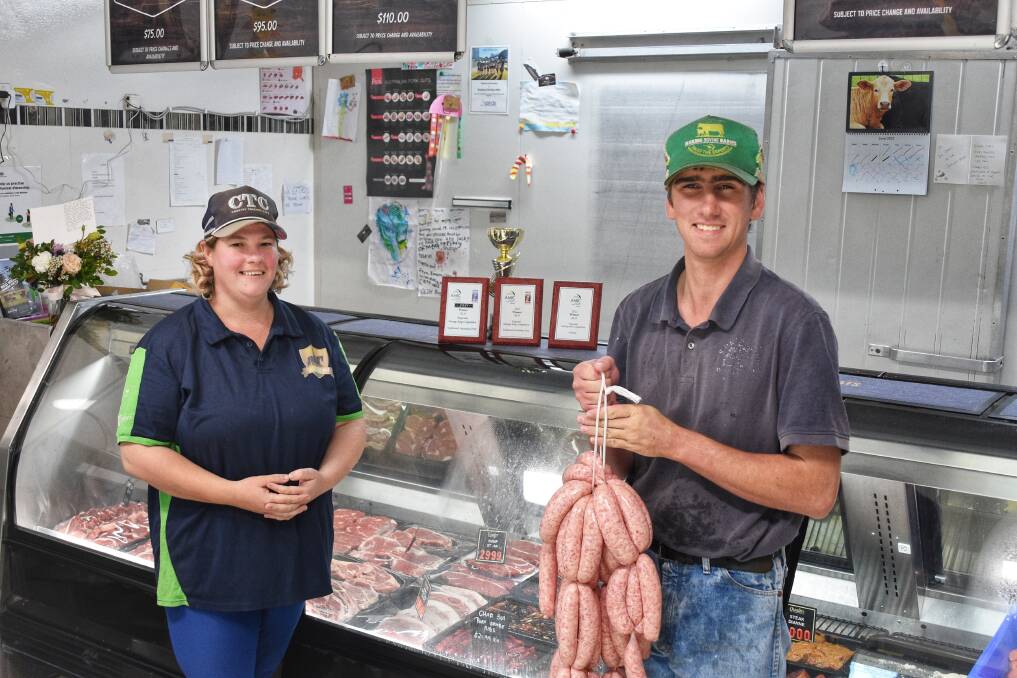 Springsure Mountain Meats owner Shiralee Smith with the store's freshly qualified butcher, Sam Monds, holding up their renowned pork sausages. Picture: Ben Harden 