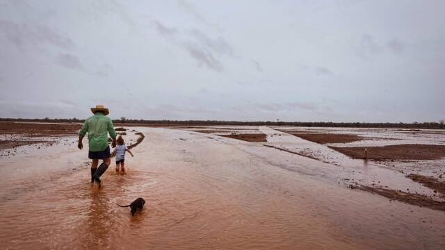 Daman Hahn with his daughter Brydie, check the paddocks after a deluge of rain dropped on their property at Burkobulla Station on Thursday. Picture: Heather Hahn