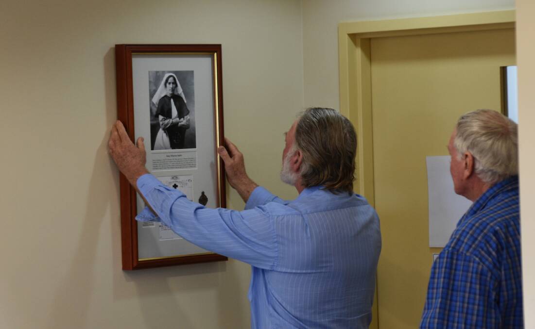 Jack and Peter Squire placing the memorial plaque on the wall at the Springsure Hospital. Picture: Ben Harden 