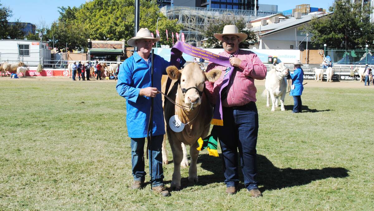 Ivan Price accepts the junior champion heifer ribbon from Charolais Society Australia president Brendan Scheiwe. 