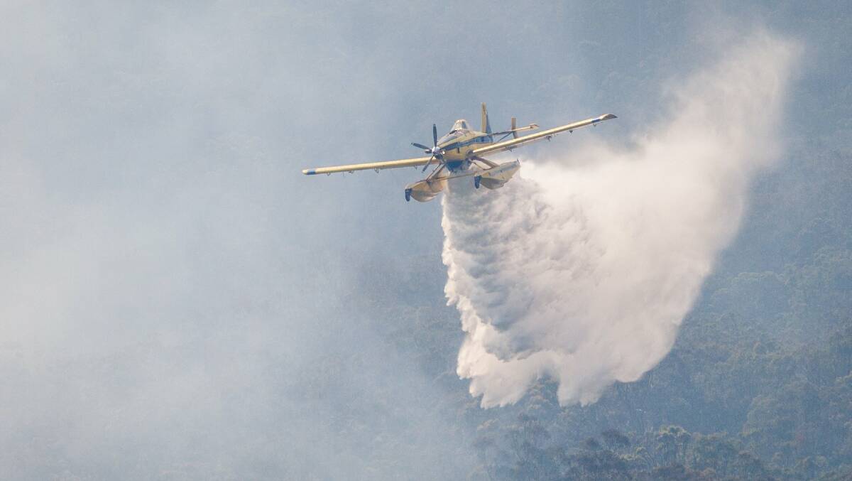 A water-bombing plane in action over the Beechmont Tarome fires. Photo- QFES. 