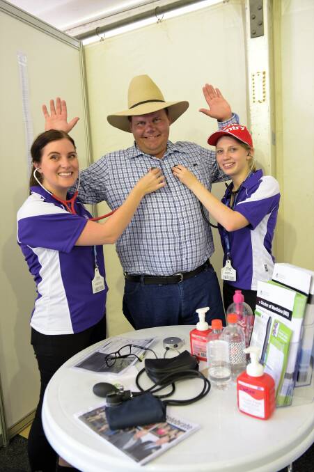 Ben Lobegeier, Enfield, Westwood, getting a health check from former UQ Rural Clinical School students Sally Freeman and Leiana Phelps at Beef 2015.