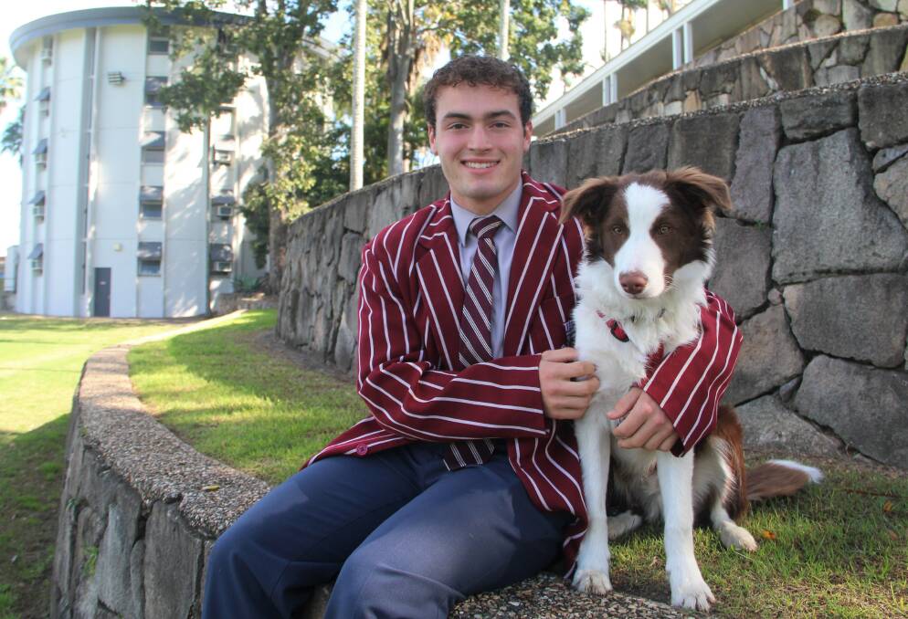 A dog's life: Ipswich Grammar student Rhys Woods with the school's boarding dog Broxy. Picture: Supplied