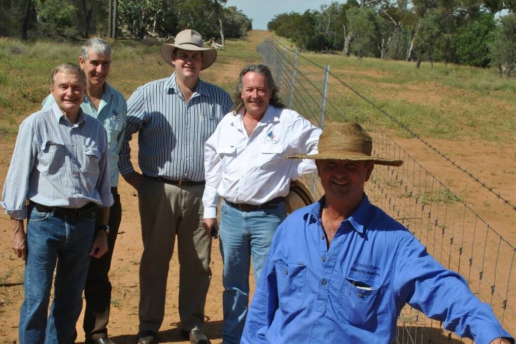 Will Roberts, Victoria Downs, Morven, shows off a section of the fence now protecting about 400,000 ha of country from wild dog attacks on about 50 properties. Inspecting the fence are Memeber for Warrego Howard Hobbs, south-west NRM chief executive officer Bernard Holland, Natural Resources Minister Andrew Cripps and south-west NRM chairman Mark O'Brien.