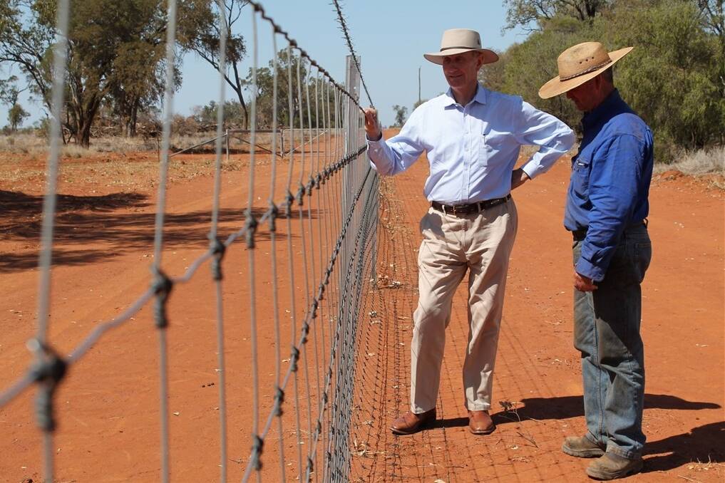 Member for Maranoa Bruce Scott, pictured here with Morven landholder Will Roberts, is calling on the state government to direct wild dog money to exclusion fencing.