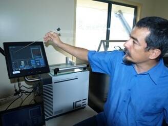 Beef Breeding Services' Cesar Castañeda shows how the computer monitors the temperature and keeps it consistent.