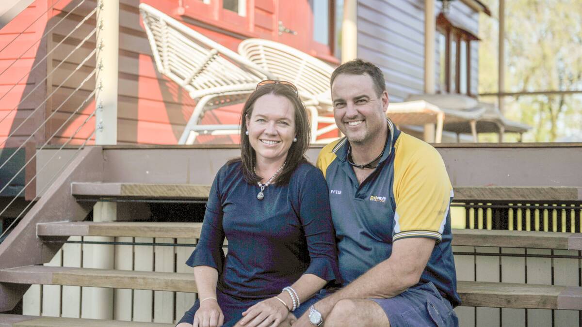 Netty and Peter Smith sit on the steps of their newly-renovated guest house. 