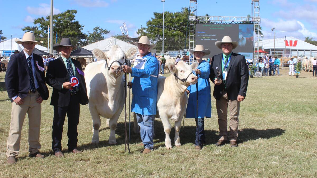 Grand champion Charolais cow was Moongool Radical held by Ivan Price, Moongool Charolais, Yuleba while Chloe Kemph holds her calf and with associate judge Justin Rohde, judge Reade Radel, and David McKechnie, Nutrien, Rockhampton. 