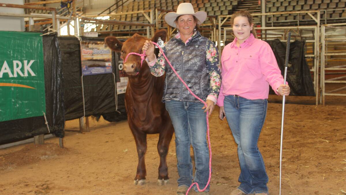 Kirrily Johnson-Iseppi and her daughter Brooke with the nine-month-old, stylish deep bodied heifer GK Diamond Mist P35 who topped the Power of Red Sale on Saturday.