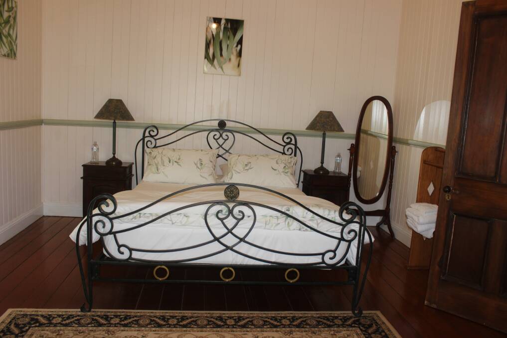 The eucalypt-inspired guest bedroom, which has a wrought iron queen size bed and antique furniture. Picture Helen Walker