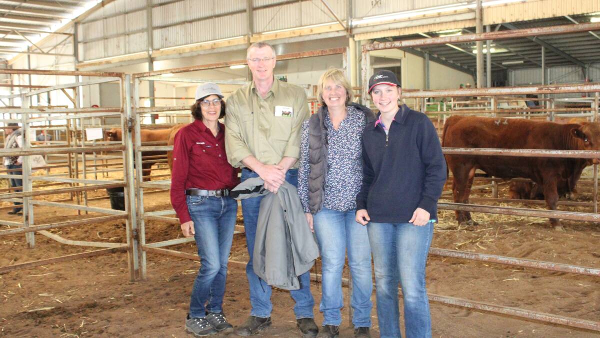 Heather Davies, with buyers of the top price cow and calf package, James, Julie and Lara Brophy. 