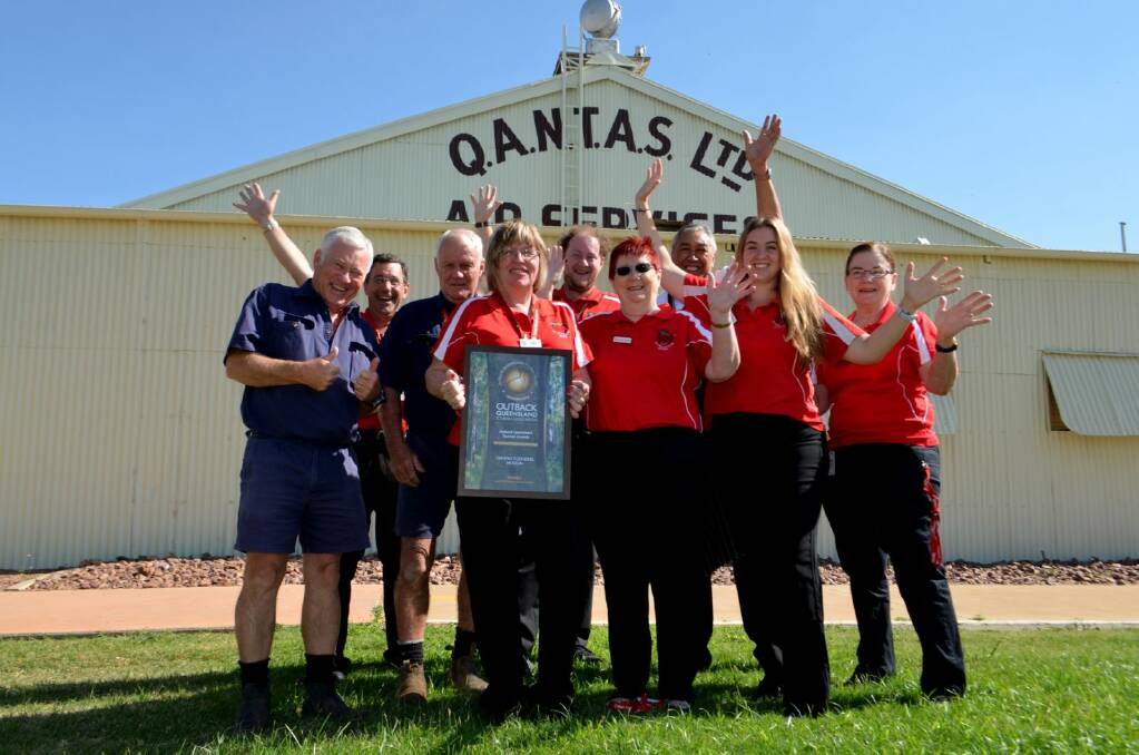 Qantas Founders Museum staff standing in front of the National Heritage Listed Qantas Hangar with the 2018 Outback Queensland Tourism Award for Major Tourist Attraction