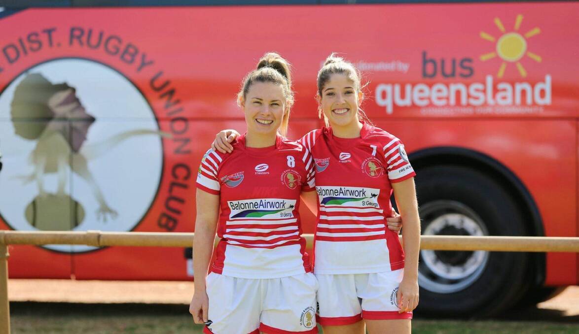 St George and District womens 7s players Claire Armstrong and Alice Rathie in front of the club's new bus.