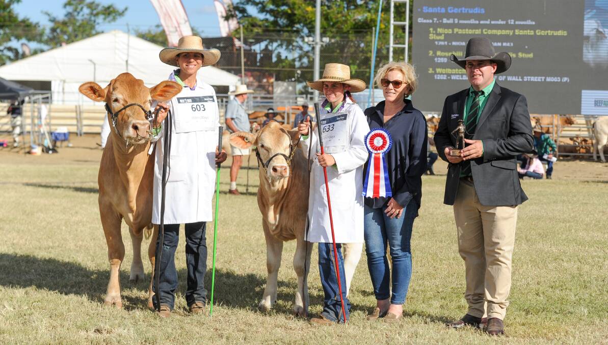 Cherie Gooding and Haley Zeimer hold the champion Charbray female with ribbon presenters Gay O'Dea of the Charbray Society and Nutrien's Dane Pearce. 