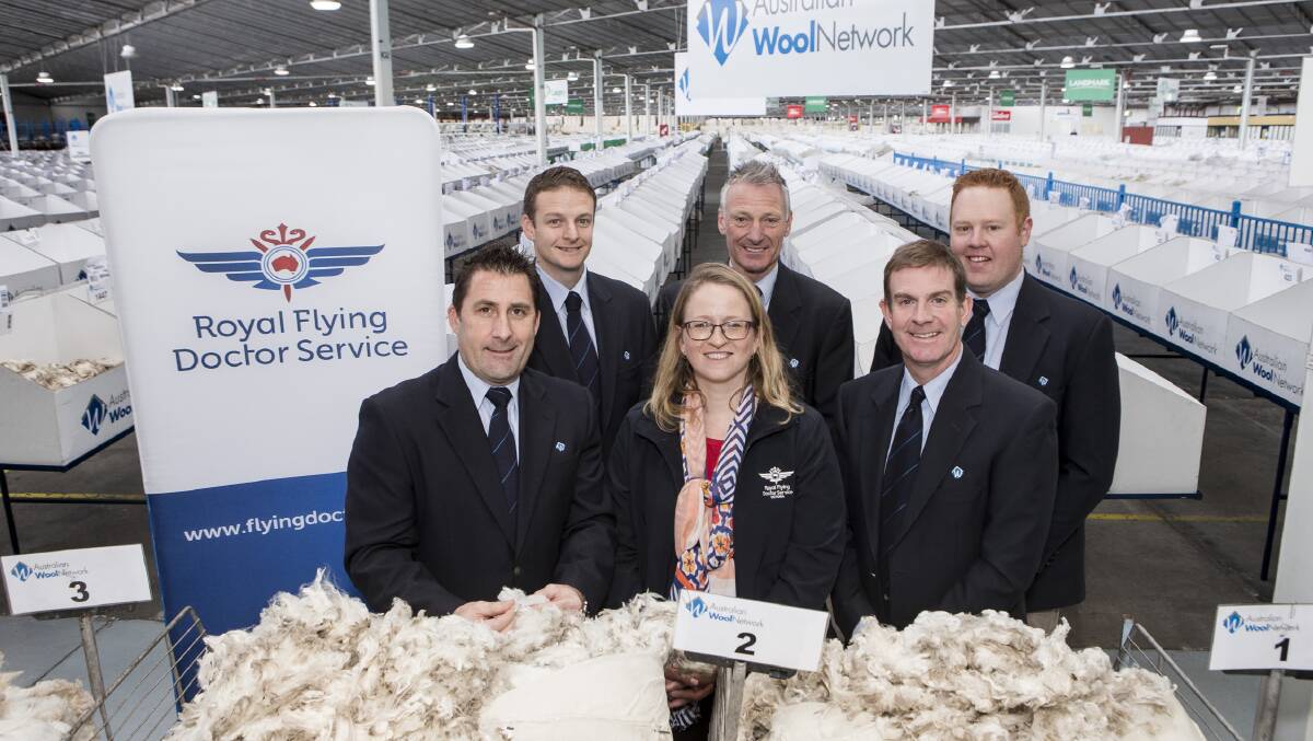 FLYING HIGH: AWN’'s Brent Squires, Kelvin Shelly, Rod Miller, Jeff Denny and Jason Rothe on the showfloor in Melbourne with RFDS representative Heather Rendell and the successful auction bales.