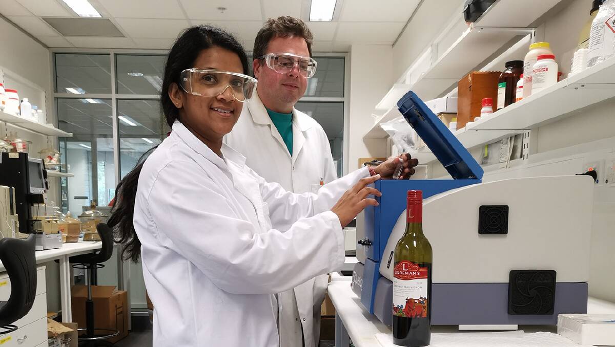 DETECTING DECEPTION: PhD student Ruchira Ranaweera loads a wine sample into the Aqualog spectrofluorometer with David Jeffery. Photo: UNIVERSITY OF ADELAIDE